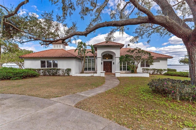 mediterranean / spanish house featuring a front lawn