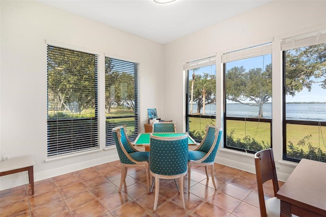 dining room featuring tile patterned flooring and a water view