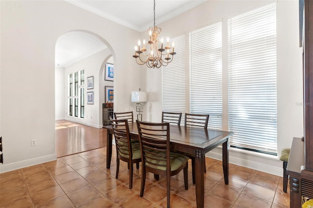 dining space with tile patterned floors, plenty of natural light, a notable chandelier, and ornamental molding