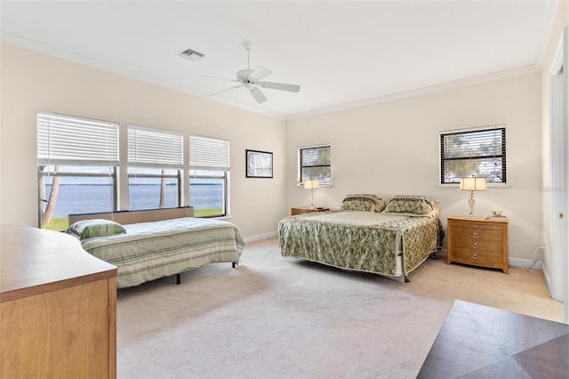 carpeted bedroom featuring multiple windows, ornamental molding, and ceiling fan