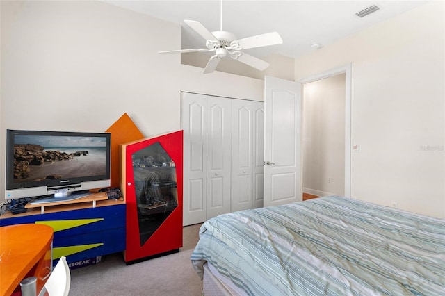 carpeted bedroom with ceiling fan and a closet