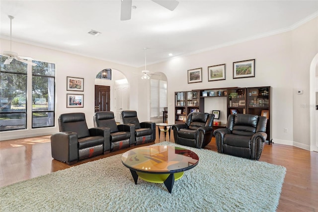 living room featuring ceiling fan, wood-type flooring, and ornamental molding