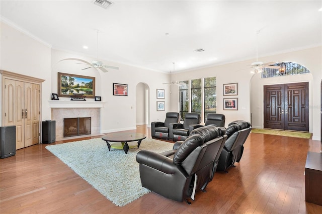 living room with ornamental molding, ceiling fan, and light hardwood / wood-style floors