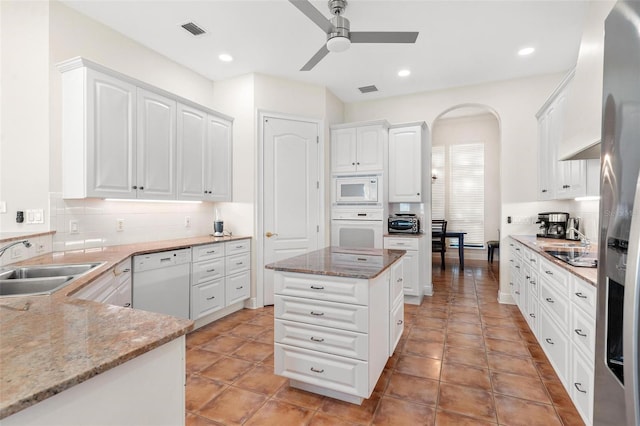 kitchen with white cabinetry, white appliances, sink, and light stone counters