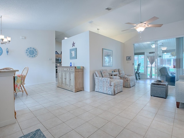 tiled living room with ceiling fan with notable chandelier and lofted ceiling