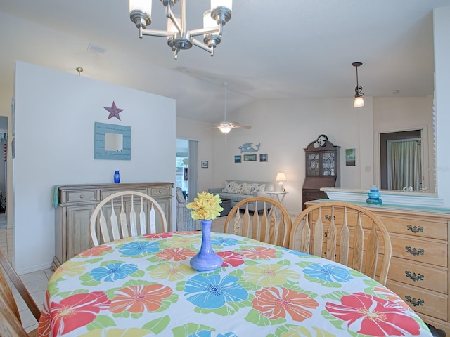 dining area with tile patterned flooring, ceiling fan with notable chandelier, and lofted ceiling