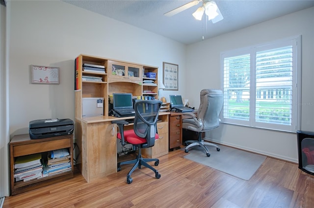 office with ceiling fan, light wood-type flooring, and a textured ceiling