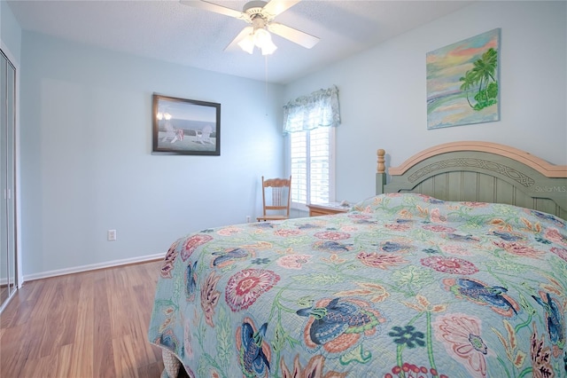 bedroom with ceiling fan, a textured ceiling, and light hardwood / wood-style flooring