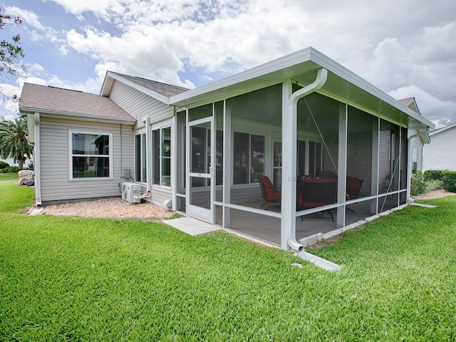 back of house with a sunroom and a yard