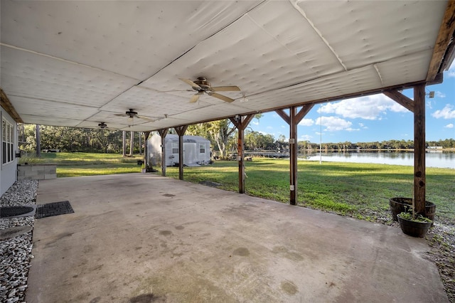 view of patio featuring a water view, ceiling fan, and a storage shed