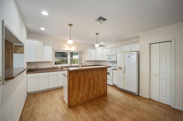 kitchen featuring white cabinetry, decorative light fixtures, white appliances, and light hardwood / wood-style floors