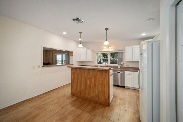 kitchen featuring light wood-type flooring, stainless steel dishwasher, white cabinetry, white fridge, and a kitchen island