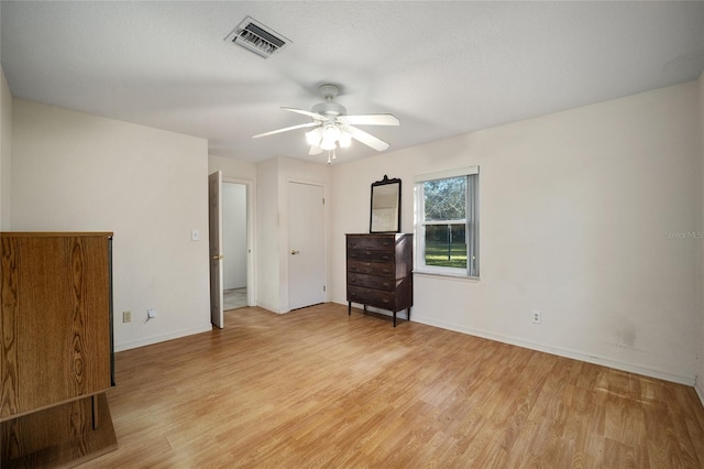 spare room featuring ceiling fan, a textured ceiling, and light wood-type flooring