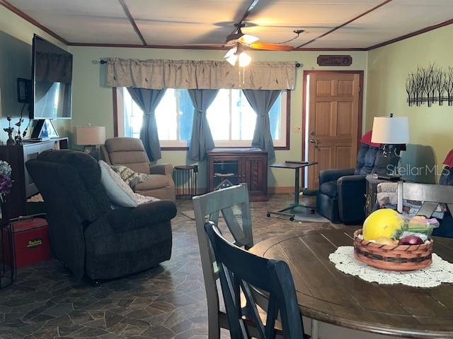 dining space with ornamental molding and ceiling fan