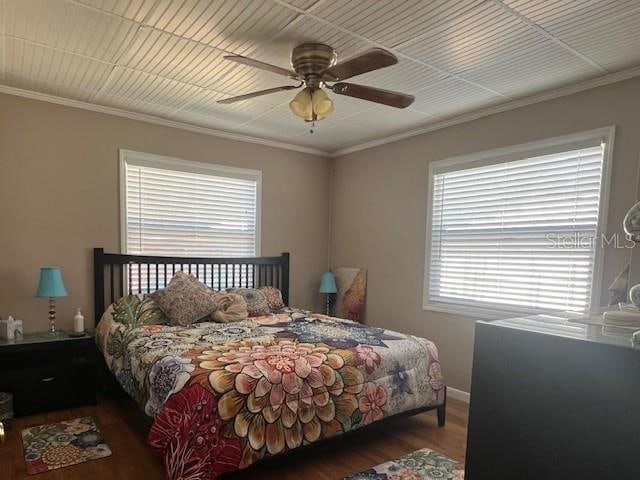 bedroom featuring hardwood / wood-style flooring, crown molding, and ceiling fan