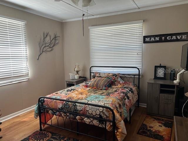 bedroom with ceiling fan, ornamental molding, and hardwood / wood-style floors