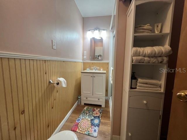 bathroom featuring vanity, hardwood / wood-style floors, and wood walls