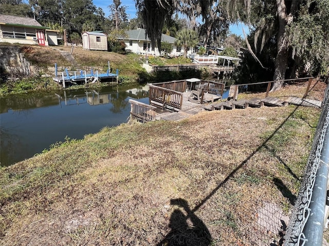 view of yard featuring a storage shed and a water view