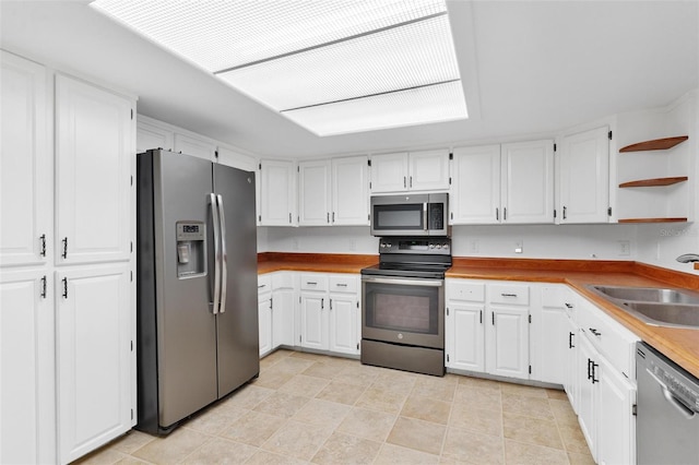 kitchen featuring white cabinets, light tile patterned flooring, sink, and stainless steel appliances