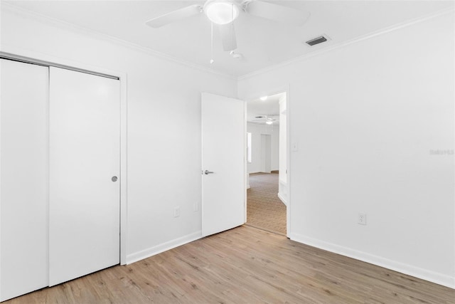 unfurnished bedroom featuring crown molding, ceiling fan, a closet, and light hardwood / wood-style floors