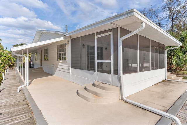 back of house with a sunroom and a carport