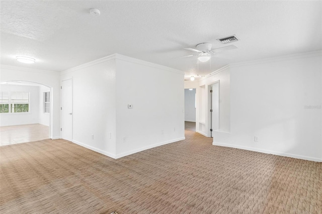 carpeted empty room featuring ceiling fan, a textured ceiling, and ornamental molding