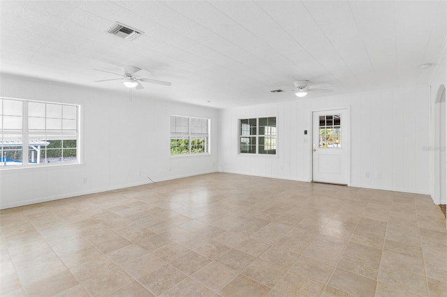 tiled spare room featuring a wealth of natural light and ceiling fan