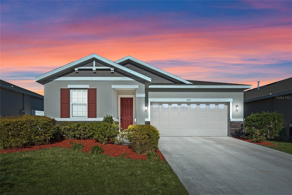 view of front of property with a yard and a garage