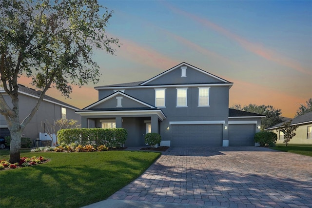 front facade featuring a yard and a garage