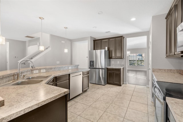 kitchen featuring sink, stainless steel appliances, decorative light fixtures, dark brown cabinets, and light tile patterned floors