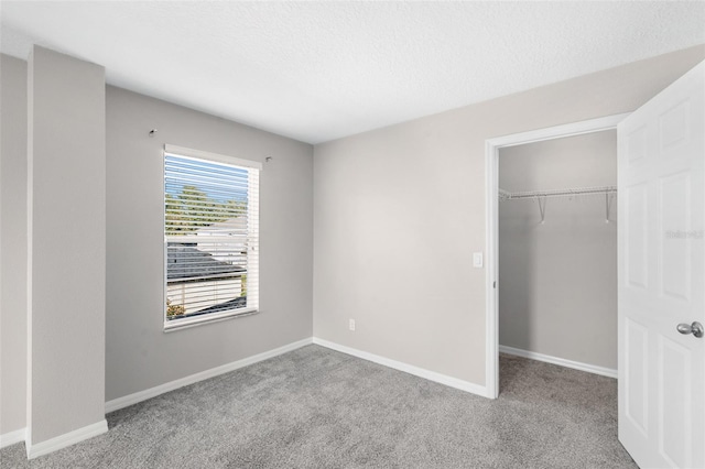 unfurnished bedroom with a textured ceiling, light colored carpet, and a closet