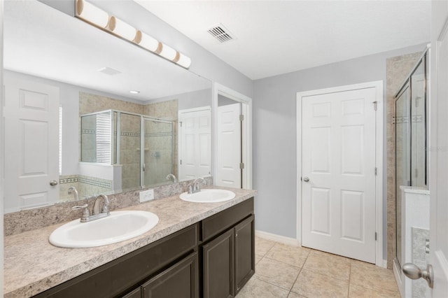 bathroom with tile patterned flooring, vanity, and an enclosed shower