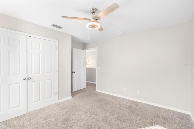 unfurnished bedroom with ceiling fan, light carpet, and a closet