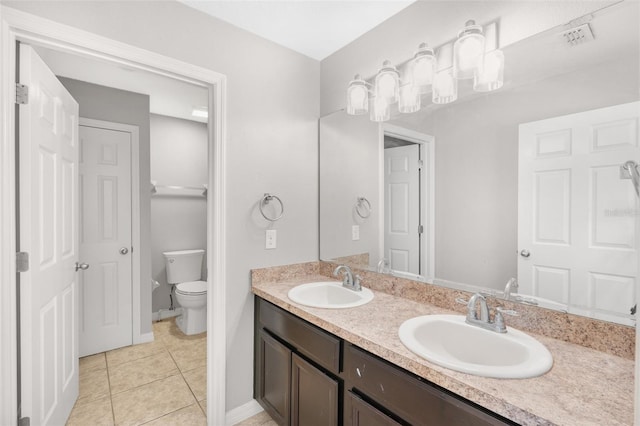 bathroom with tile patterned flooring, vanity, and toilet