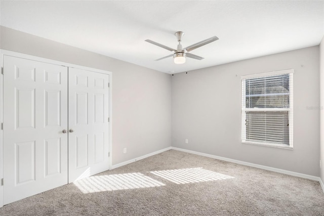 unfurnished bedroom featuring a closet, light colored carpet, and ceiling fan