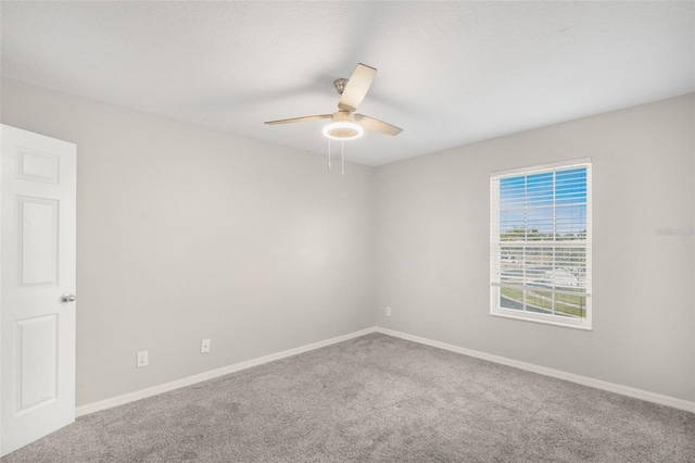 carpeted spare room with ceiling fan