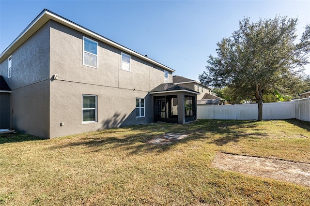 back of house featuring a sunroom and a yard