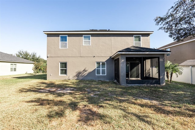 back of property featuring a sunroom and a yard