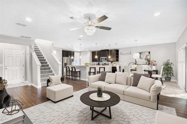 living room with light hardwood / wood-style flooring and ceiling fan