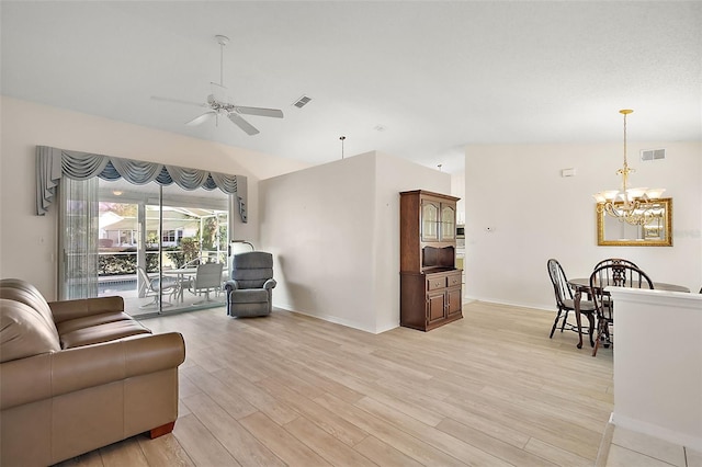 living room featuring ceiling fan with notable chandelier and light hardwood / wood-style floors