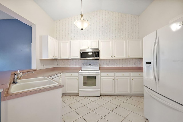 kitchen featuring white appliances, vaulted ceiling, sink, pendant lighting, and white cabinetry