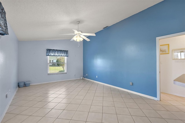 tiled spare room featuring ceiling fan, a textured ceiling, and vaulted ceiling