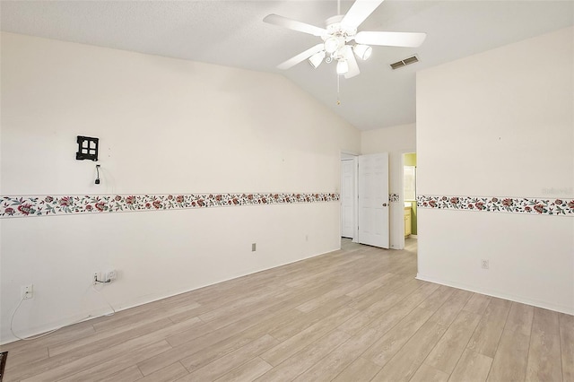 empty room with ceiling fan, light wood-type flooring, a textured ceiling, and vaulted ceiling