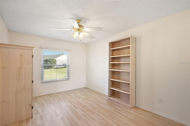 unfurnished room featuring a textured ceiling, light hardwood / wood-style floors, and ceiling fan