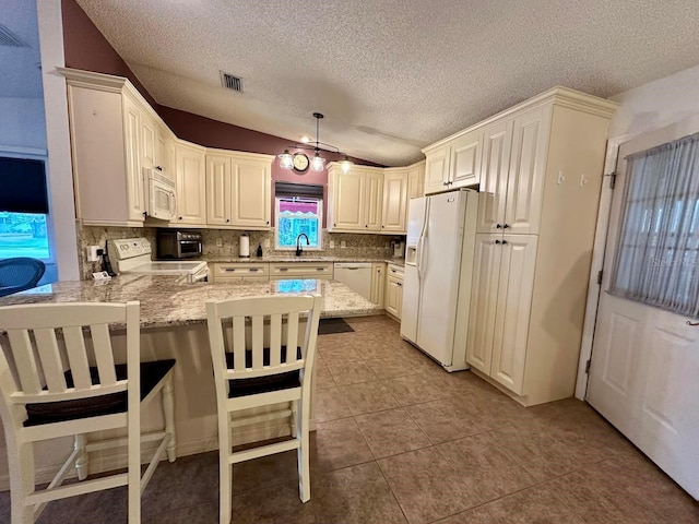 kitchen with kitchen peninsula, a kitchen breakfast bar, tasteful backsplash, white appliances, and decorative light fixtures