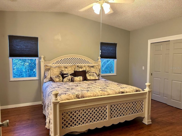 bedroom featuring dark wood-type flooring, vaulted ceiling, ceiling fan, a textured ceiling, and a closet