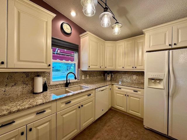 kitchen with sink, tasteful backsplash, light stone counters, pendant lighting, and white appliances