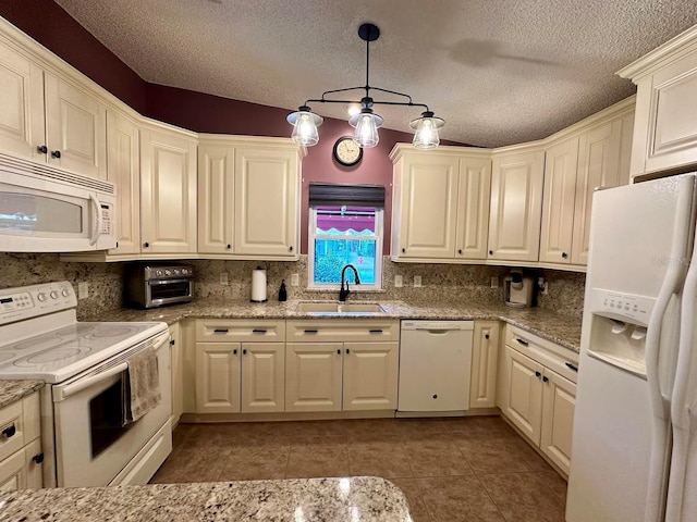 kitchen with light stone counters, white appliances, a textured ceiling, sink, and pendant lighting