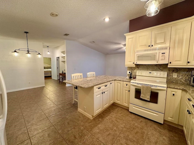 kitchen featuring kitchen peninsula, decorative backsplash, white appliances, vaulted ceiling, and decorative light fixtures