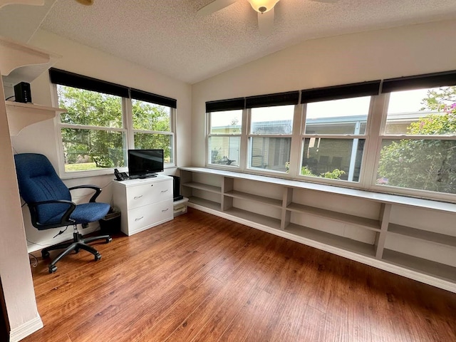 home office featuring lofted ceiling, ceiling fan, wood-type flooring, and a textured ceiling